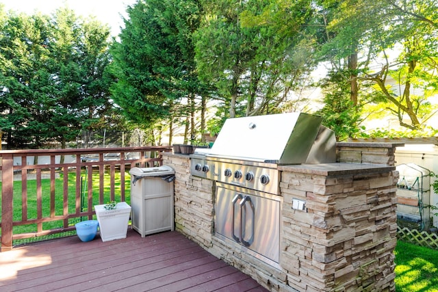 wooden terrace featuring an outdoor kitchen, fence, and area for grilling