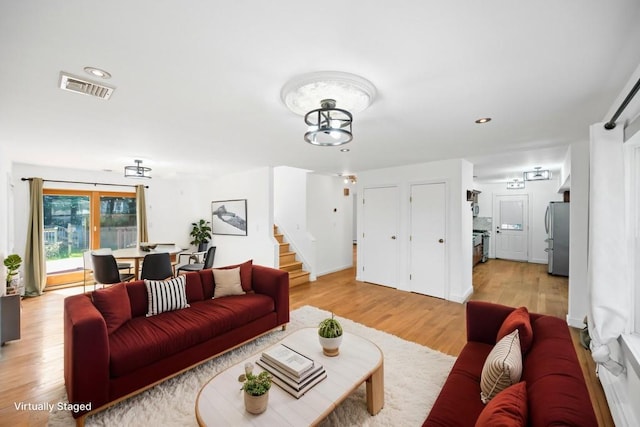 living room featuring recessed lighting, stairway, a chandelier, visible vents, and light wood-style flooring