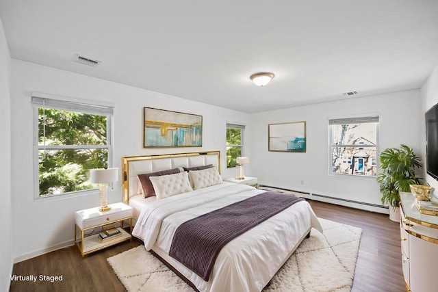 bedroom featuring multiple windows, baseboard heating, and visible vents