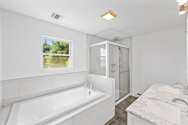 full bath featuring visible vents, a garden tub, a stall shower, and a sink