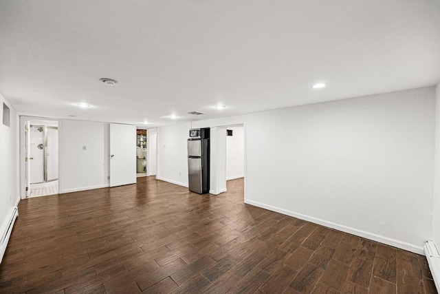 interior space with baseboard heating, refrigerator, dark wood finished floors, and baseboards