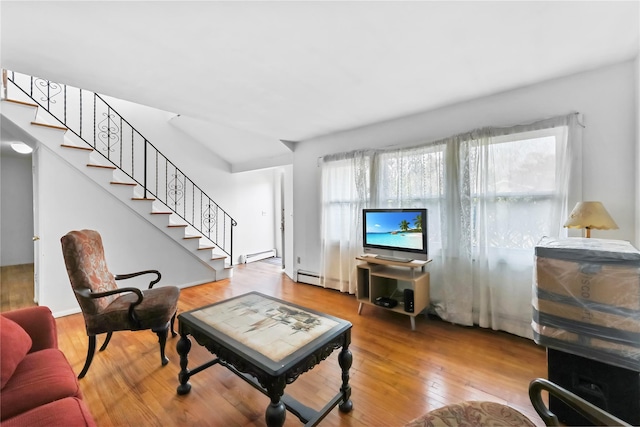 living room featuring stairs, wood finished floors, and a baseboard radiator