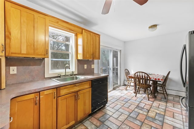 kitchen with a ceiling fan, freestanding refrigerator, black dishwasher, baseboard heating, and a sink