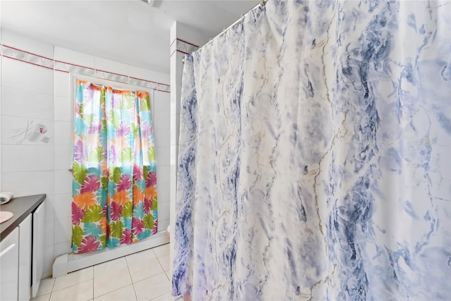 full bathroom featuring vanity, tile walls, tile patterned floors, a shower with curtain, and a baseboard radiator