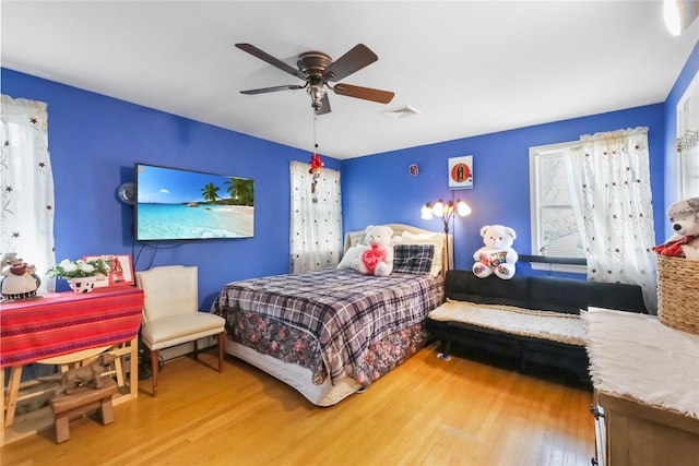 bedroom with visible vents, a ceiling fan, and wood finished floors