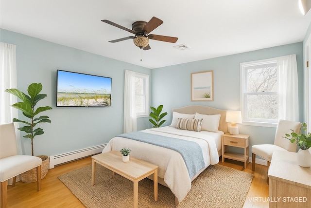 60 School St, Hampton Bays, NY 11946 - bedroom featuring baseboard heating, light wood finished floors, and a ceiling fan