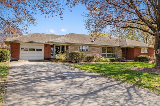 ranch-style home with an attached garage, a front lawn, aphalt driveway, and brick siding