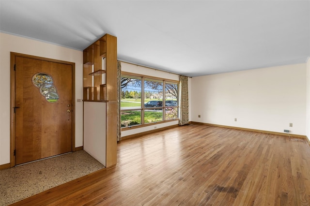 foyer featuring baseboards and light wood-type flooring