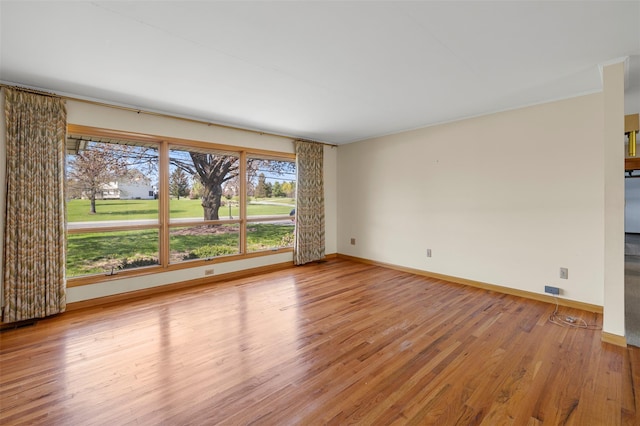 unfurnished room featuring baseboards and wood finished floors