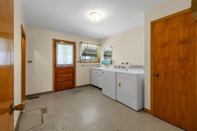 washroom featuring visible vents, baseboards, separate washer and dryer, a sink, and cabinet space
