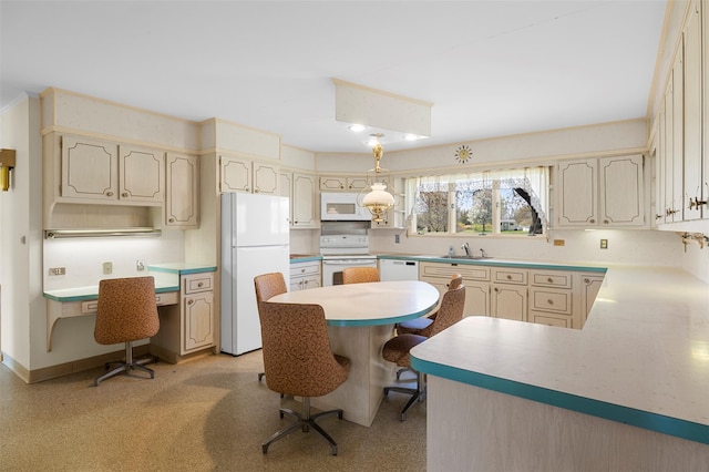kitchen with white appliances, a breakfast bar area, a sink, and light countertops