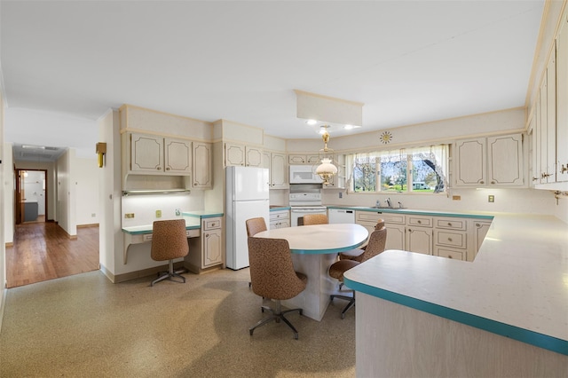 kitchen with baseboards, a sink, white appliances, and light countertops