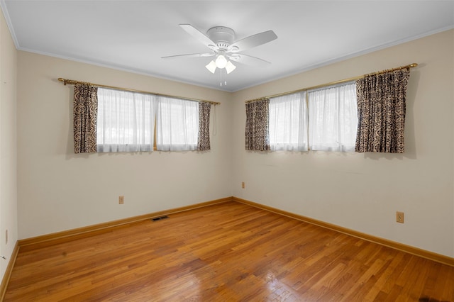 unfurnished room featuring a healthy amount of sunlight, ceiling fan, light wood-type flooring, and visible vents