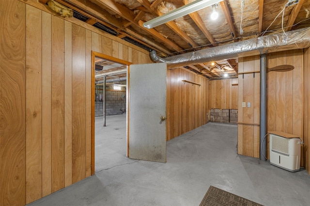unfinished basement featuring wood walls
