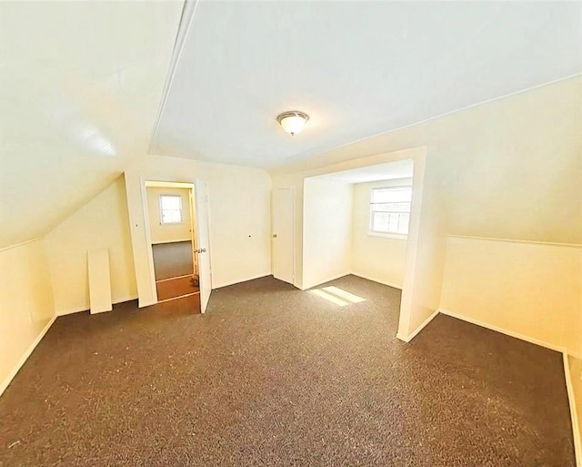 bonus room featuring baseboards, a healthy amount of sunlight, and lofted ceiling