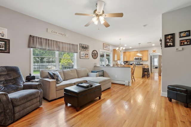 27 Lindbergh Ln, New City, NY 10956 - living room featuring recessed lighting, a baseboard heating unit, ceiling fan with notable chandelier, and light wood-type flooring