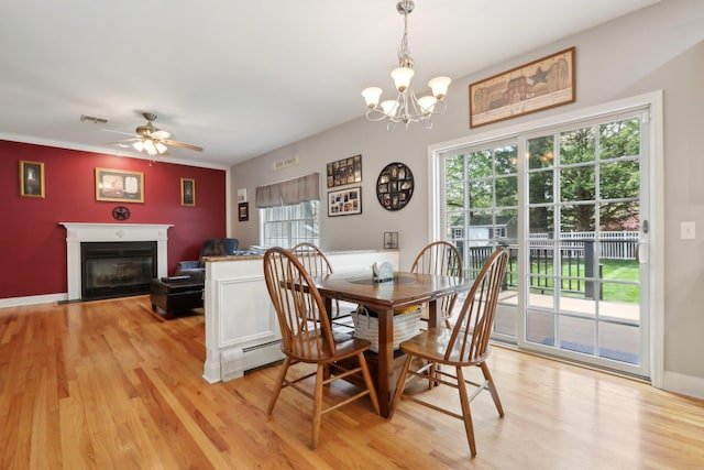 27 Lindbergh Ln, New City, NY 10956 - dining area with light wood finished floors, a glass covered fireplace, ceiling fan with notable chandelier, baseboards, and visible vents