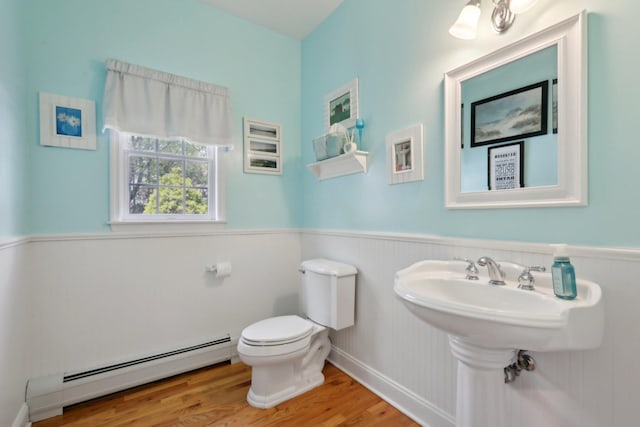 27 Lindbergh Ln, New City, NY 10956 - bathroom featuring a wainscoted wall, a baseboard heating unit, toilet, and wood finished floors