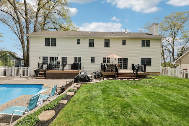 27 Lindbergh Ln, New City, NY 10956 - back of property with a fenced in pool, a wooden deck, a fenced backyard, and a chimney