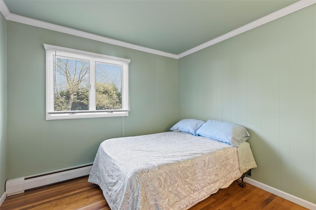 bedroom with baseboards, a baseboard heating unit, ornamental molding, and wood finished floors