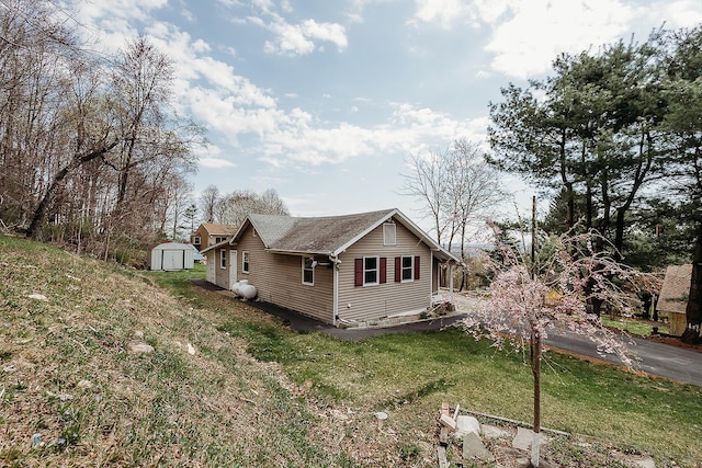 view of home's exterior with an outbuilding, a shed, and a lawn