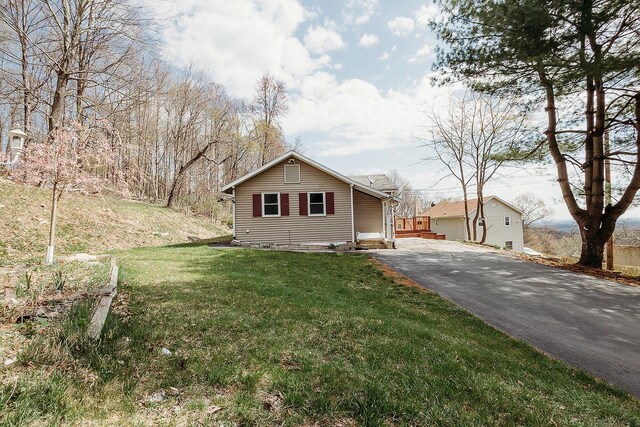 view of front of property featuring aphalt driveway and a front lawn