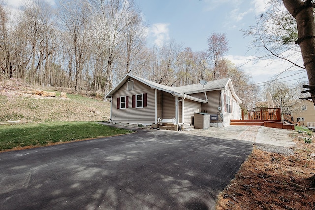view of home's exterior featuring a deck and driveway