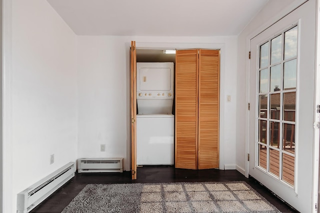 laundry room with stacked washer and dryer, laundry area, and a baseboard heating unit