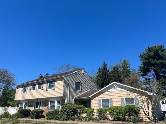 19 Millbrook Dr, Stony Brook, NY 11790 - view of front of home with fence and a chimney
