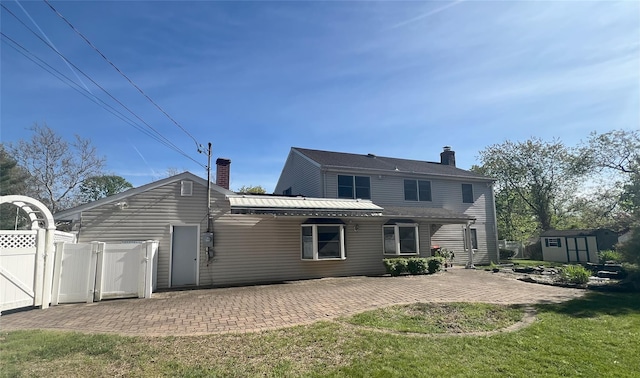 19 Millbrook Dr, Stony Brook, NY 11790 - back of property with fence, a storage shed, a chimney, a patio area, and an outdoor structure