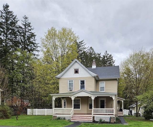 view of front facade featuring covered porch, a chimney, and a front lawn