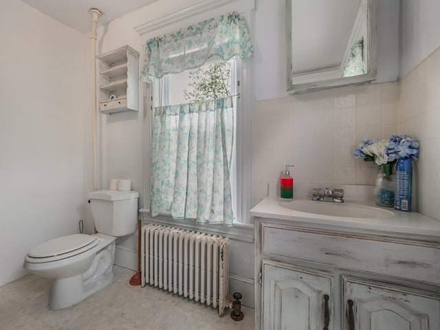 31 Highland Ave, Otisville, NY 10963 - half bathroom with radiator heating unit, toilet, vanity, decorative backsplash, and tile walls
