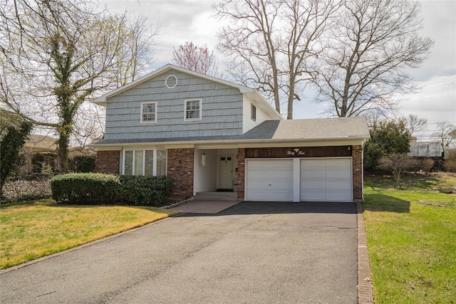 traditional home featuring brick siding, aphalt driveway, a front yard, and a garage