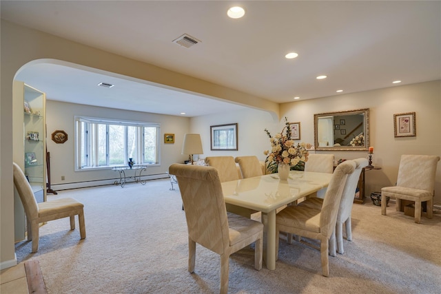 carpeted dining space featuring recessed lighting, arched walkways, a baseboard heating unit, and visible vents