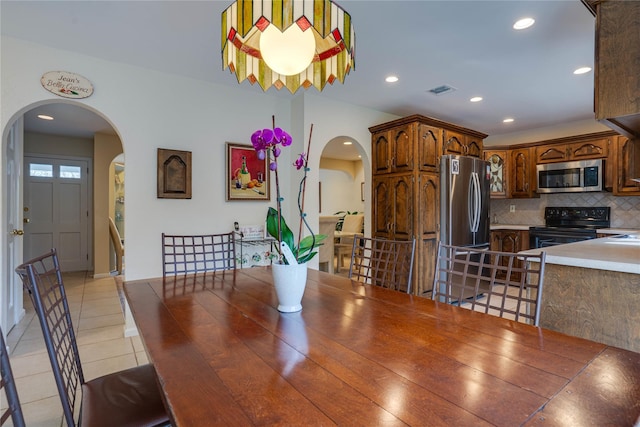dining area with light tile patterned floors, arched walkways, recessed lighting, and visible vents