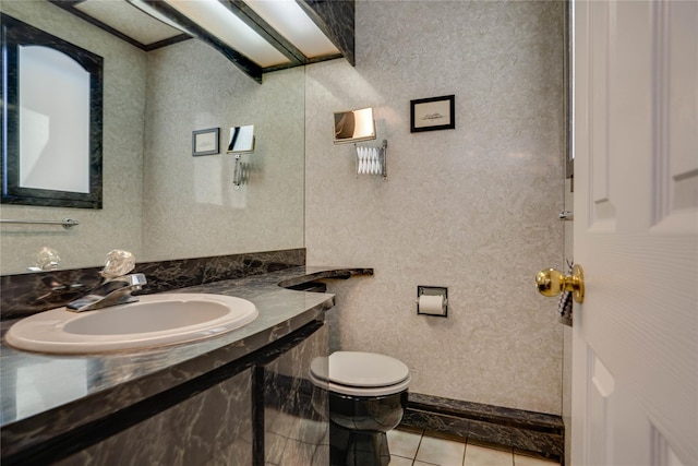 bathroom with toilet, tile patterned floors, and a sink