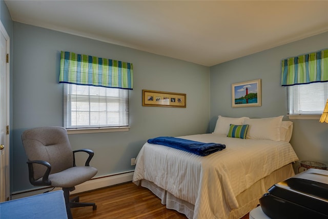 bedroom with a baseboard radiator, multiple windows, and wood finished floors