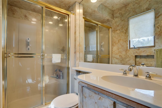 full bath with vanity, a shower stall, and toilet
