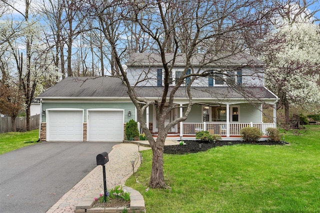 traditional-style house with a porch, driveway, a garage, fence, and a front lawn