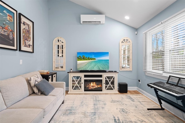 living area with a glass covered fireplace, lofted ceiling, wood finished floors, baseboards, and an AC wall unit