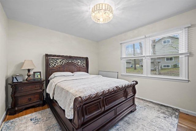 bedroom with baseboards and wood finished floors