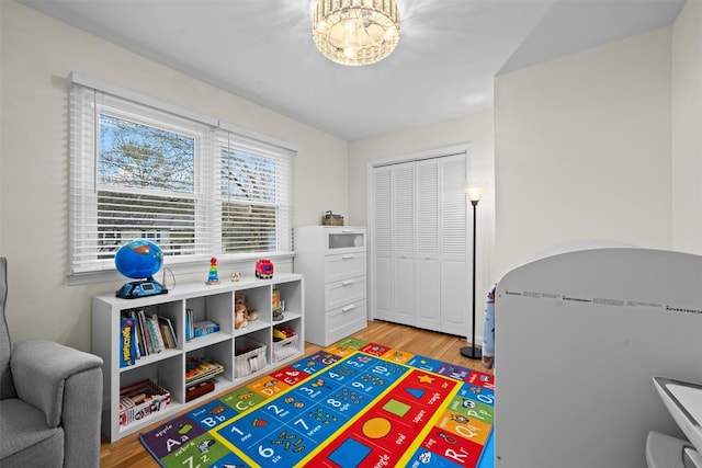 game room with wood finished floors and a chandelier