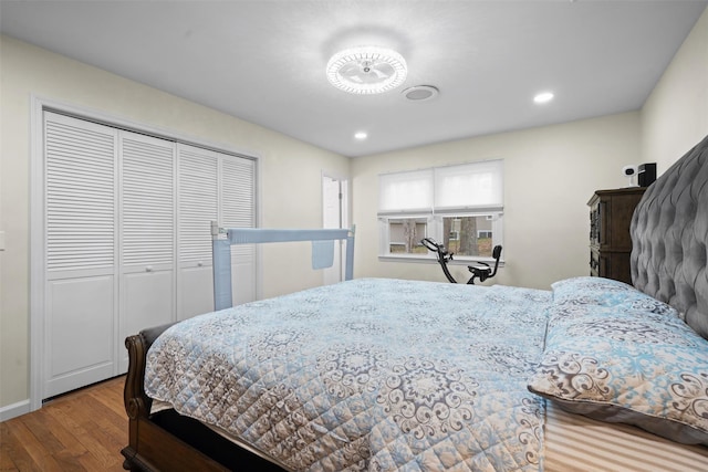 bedroom with recessed lighting, baseboards, wood finished floors, and a closet