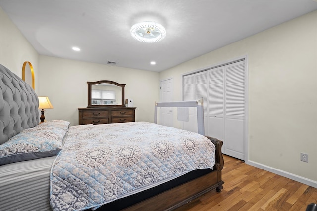 bedroom featuring visible vents, a closet, wood finished floors, baseboards, and recessed lighting