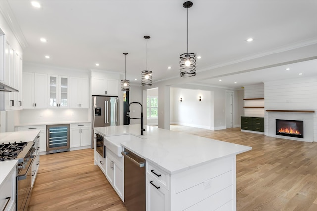 33 Lagoon Ct, Jamesport, NY 11901 - kitchen with beverage cooler, stainless steel appliances, a sink, light wood-style floors, and ornamental molding