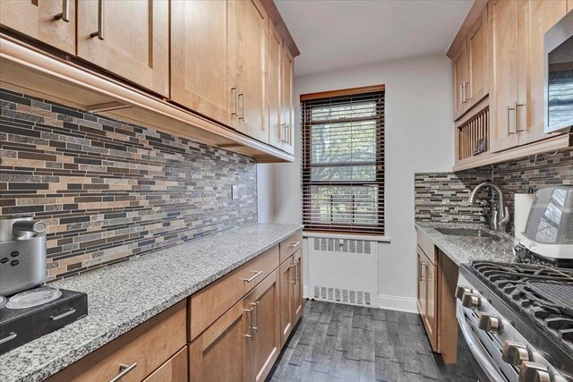 19 Rockledge Rd Unit 1A, Hartsdale, NY 10530 - kitchen with radiator, a sink, decorative backsplash, and light stone counters