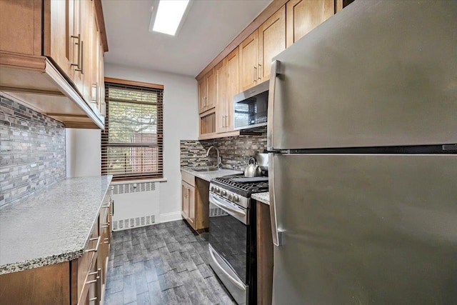 19 Rockledge Rd Unit 1A, Hartsdale, NY 10530 - kitchen featuring appliances with stainless steel finishes, dark wood-style flooring, a sink, decorative backsplash, and radiator