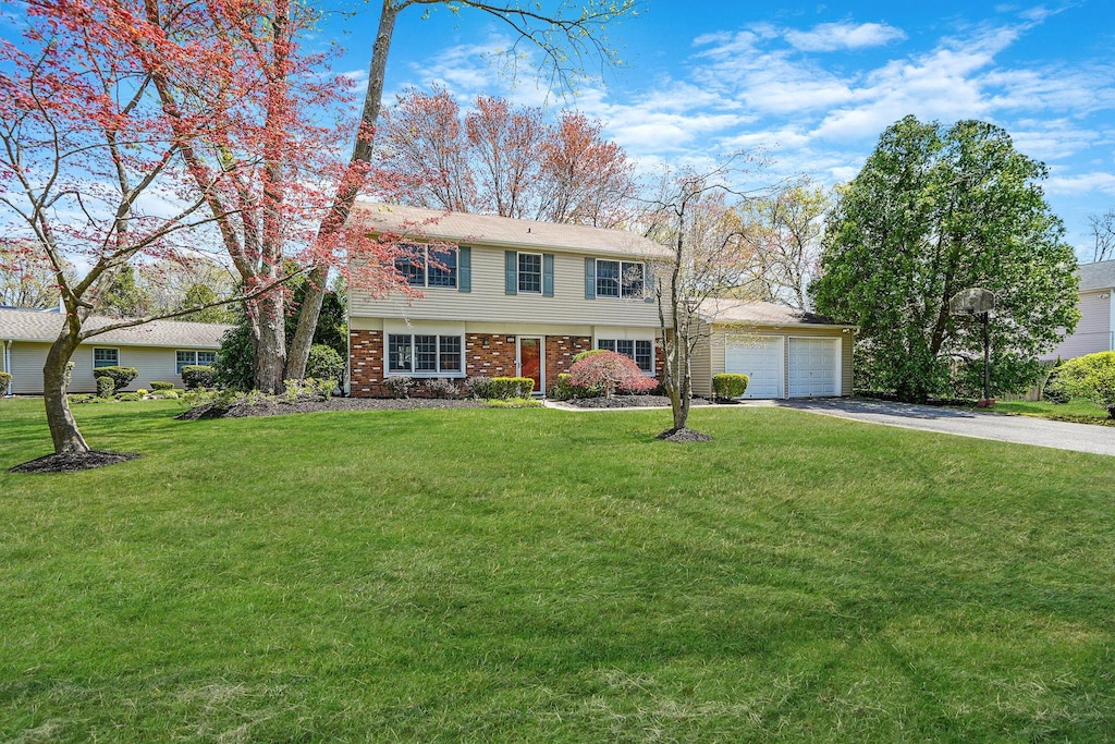 18 Botany Ln, Stony Brook, NY 11790 - view of front of house featuring a garage, a front yard, brick siding, and aphalt driveway