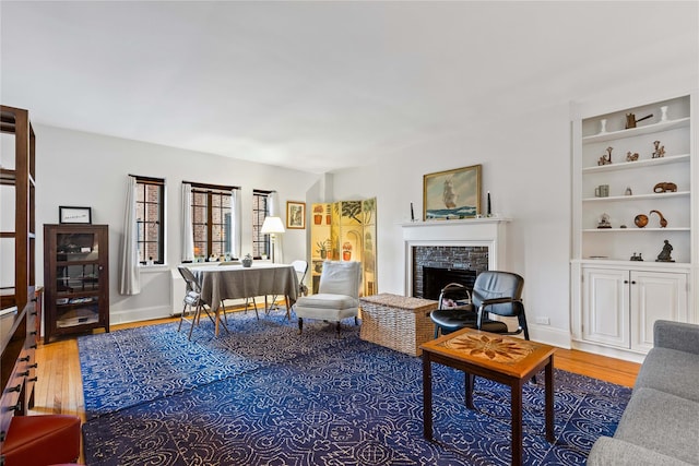 living room featuring baseboards, wood finished floors, and a tile fireplace