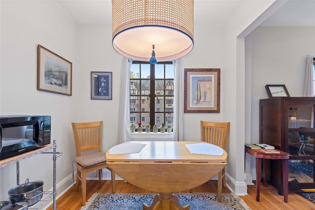 dining space with baseboards and wood finished floors